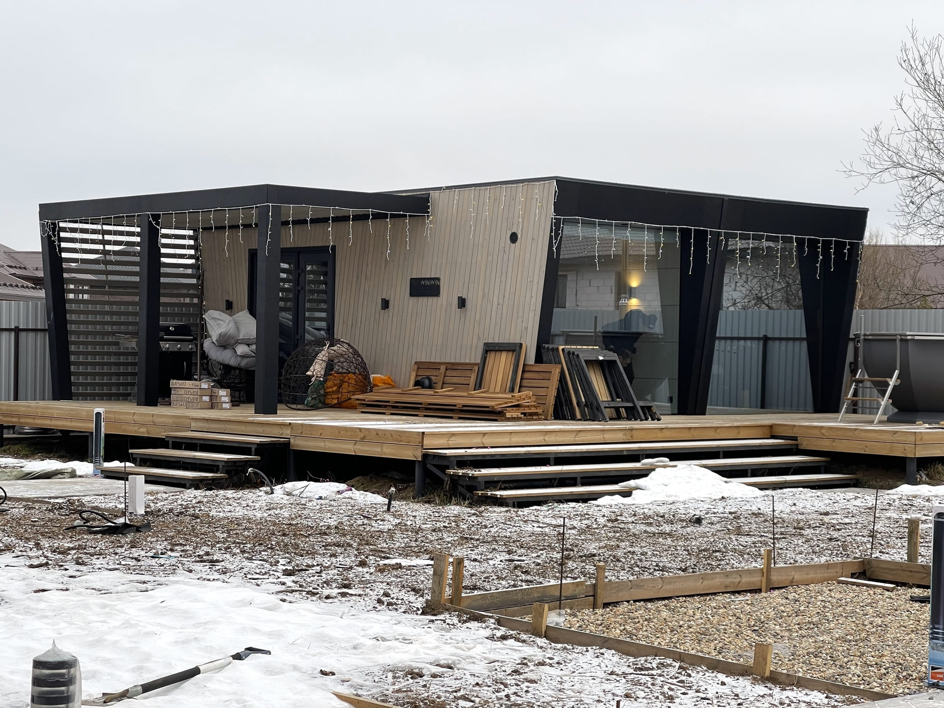 Домик WIN WIN House с панорамными окнами и террасой на заснеженном участке